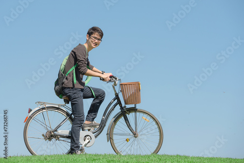Happy student rides a bicycle in park