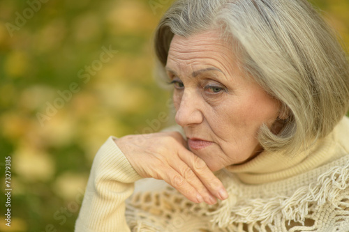 Sad old woman in park