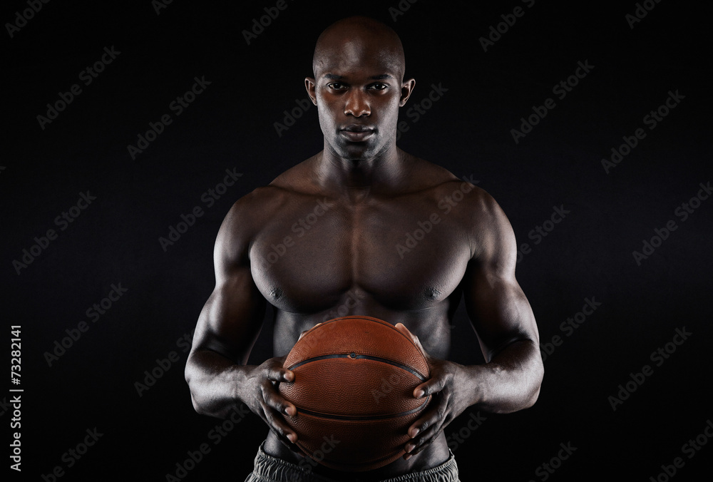 Muscular young man shirtless holding a basketball Muscular young man shirtless holding a basketball