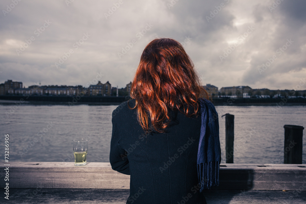 Fototapeta premium Woman drinking beer by the river