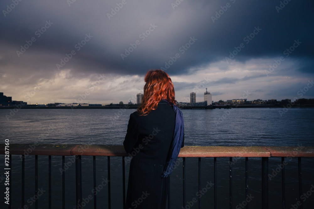 Woman admiring sunet over river in city