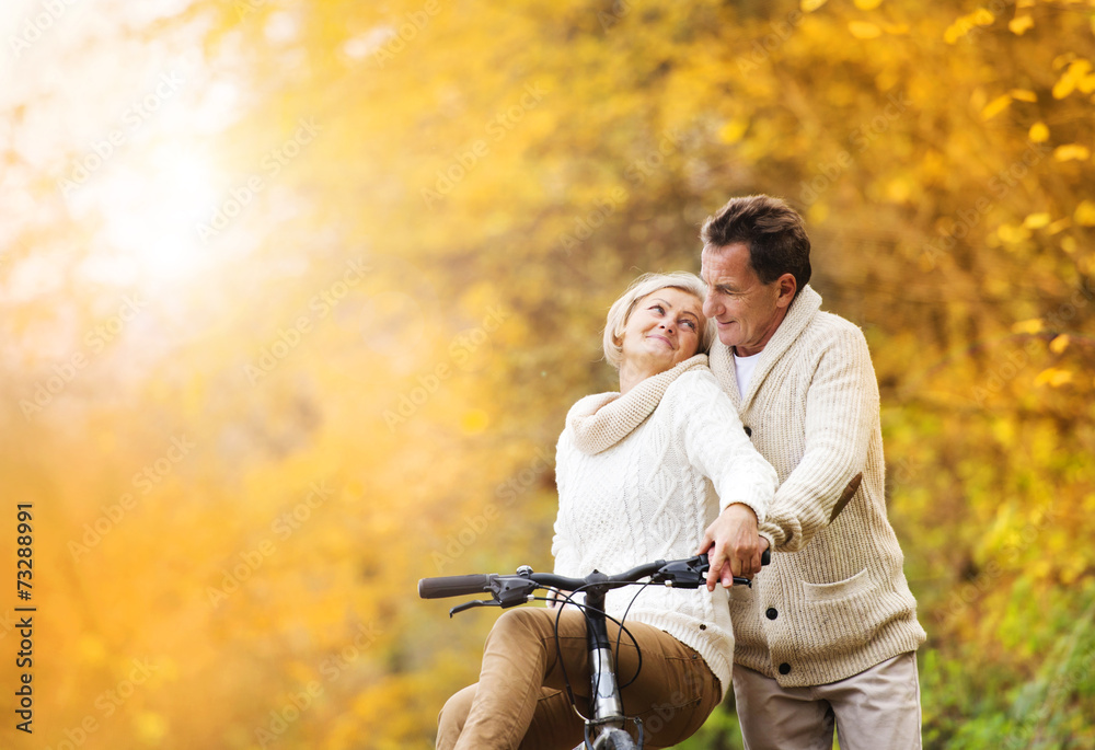 Fototapeta premium Senior couple with bicycle in autumn park