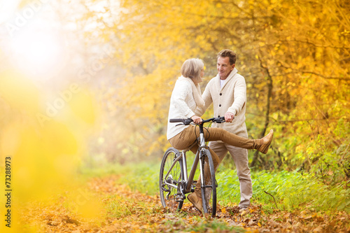 Senior couple with bicycle in autumn park