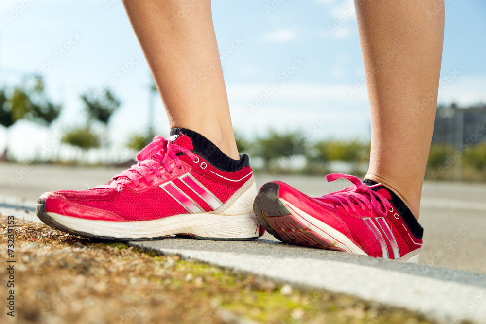 Runner feet preparing for running on road closeup on shoe.