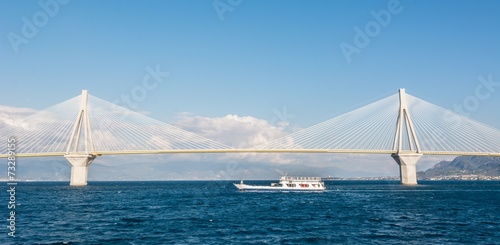 Ferry boat sailing under suspension bridge