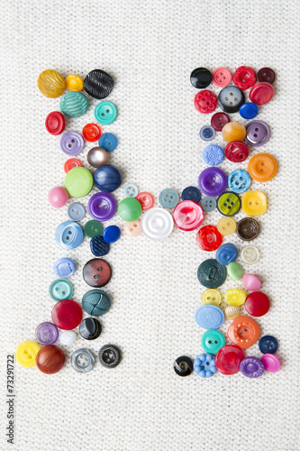 Letter H of the alphabet of buttons of various shapes and colors