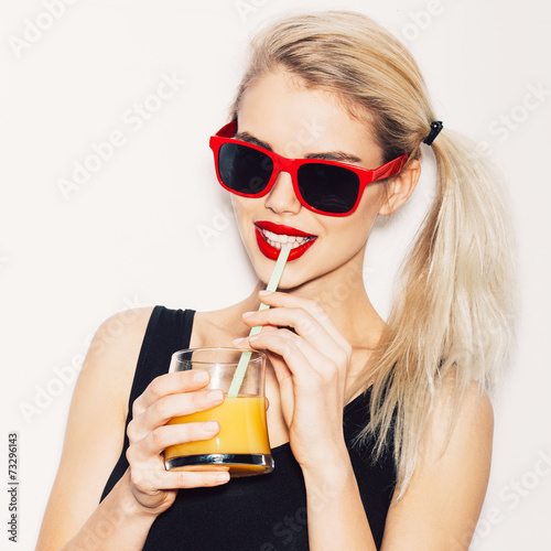 Pretty smiling blonde woman in sunglasses with cocktail