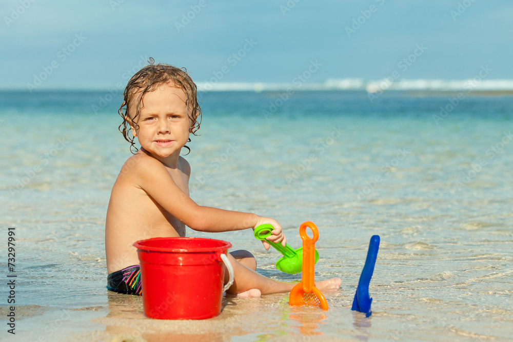 little boy playing on the beach at the day time little boy playing on the beach at the day time
