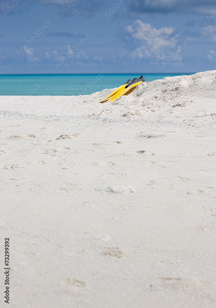 Idyllic beach of Indian ocean with yellow flippers Idyllic beach of Indian ocean with yellow flippers