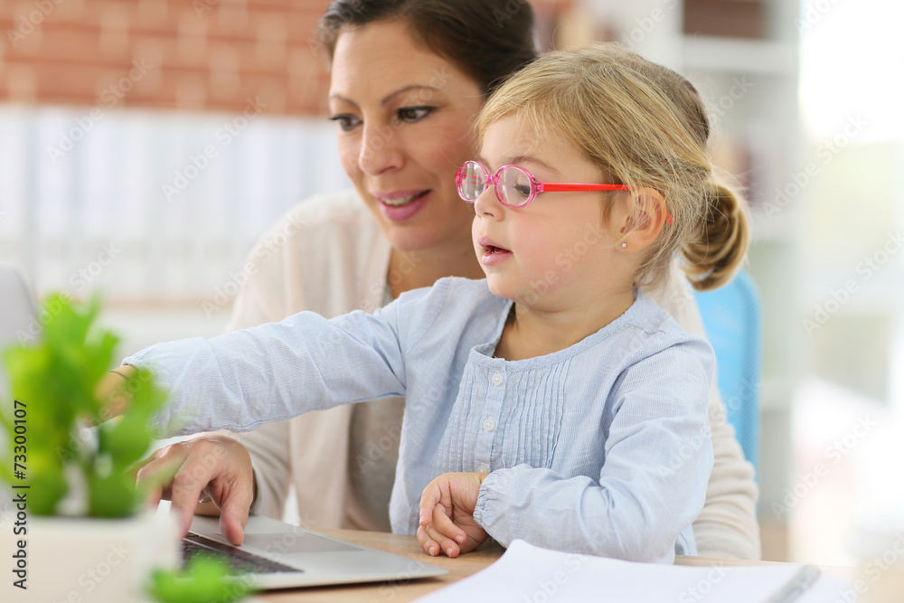 Mother working at home-office with daughter on her lap Mother working at home-office with daughter on her lap