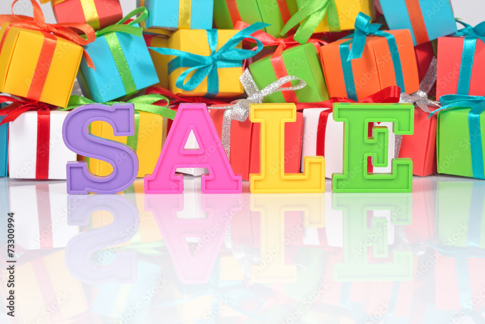 Sale written by colorful letters on the background of gifts Sale written by colorful letters on the background of gifts