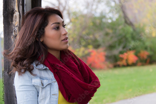 Stylish woman with red scarf posing outdoors on a fall day