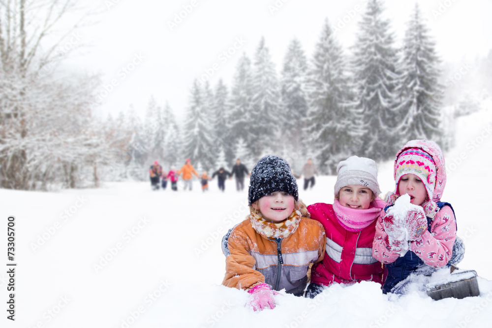 Happy family winter fun outdoors. Active parents with kids runni