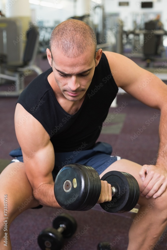 Young man exercising with dumbbell in gym Young man exercising with dumbbell in gym