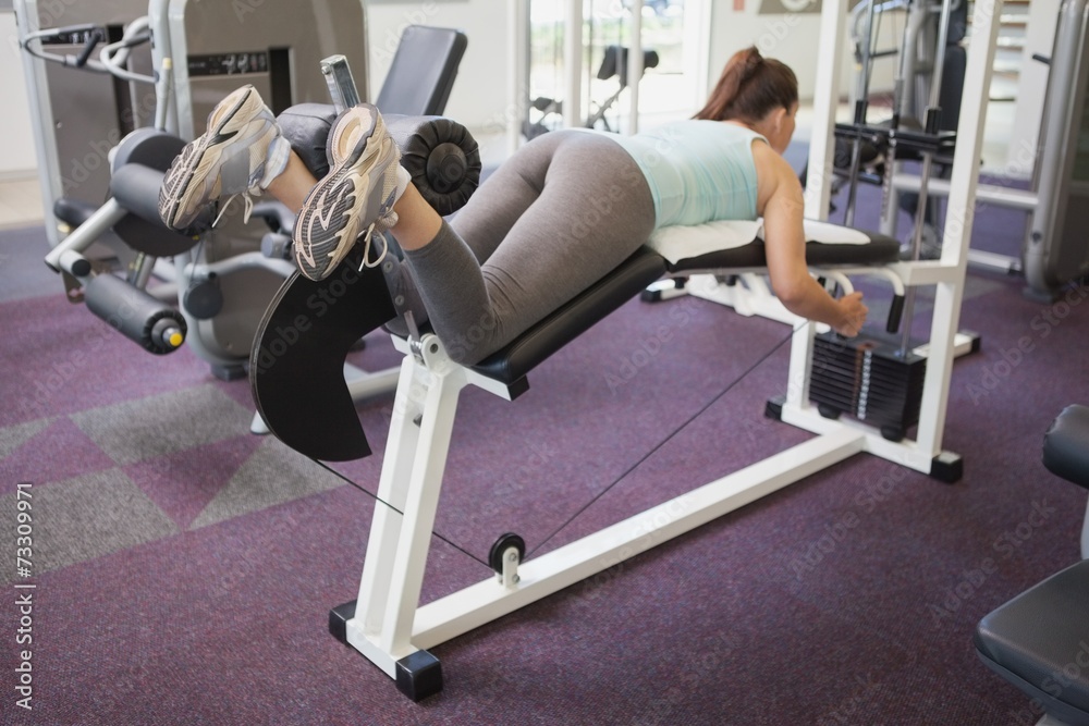 Fit brunette using weights machine for legs