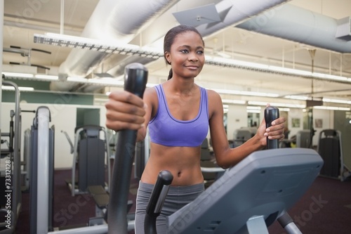 Fit woman working out on the cross trainer