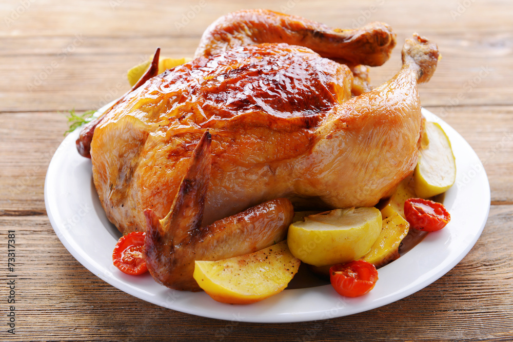 Delicious baked chicken on plate on table close-up Delicious baked chicken on plate on table close-up