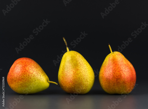 Three pears against  dark background photo