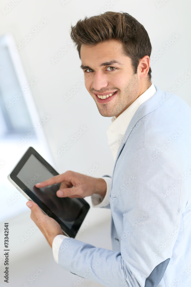 Attractive smiling man with jacket using digital tablet Attractive smiling man with jacket using digital tablet