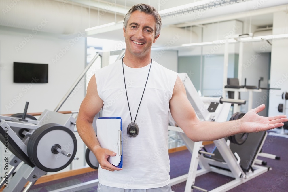 Fit personal trainer smiling at camera in fitness studio