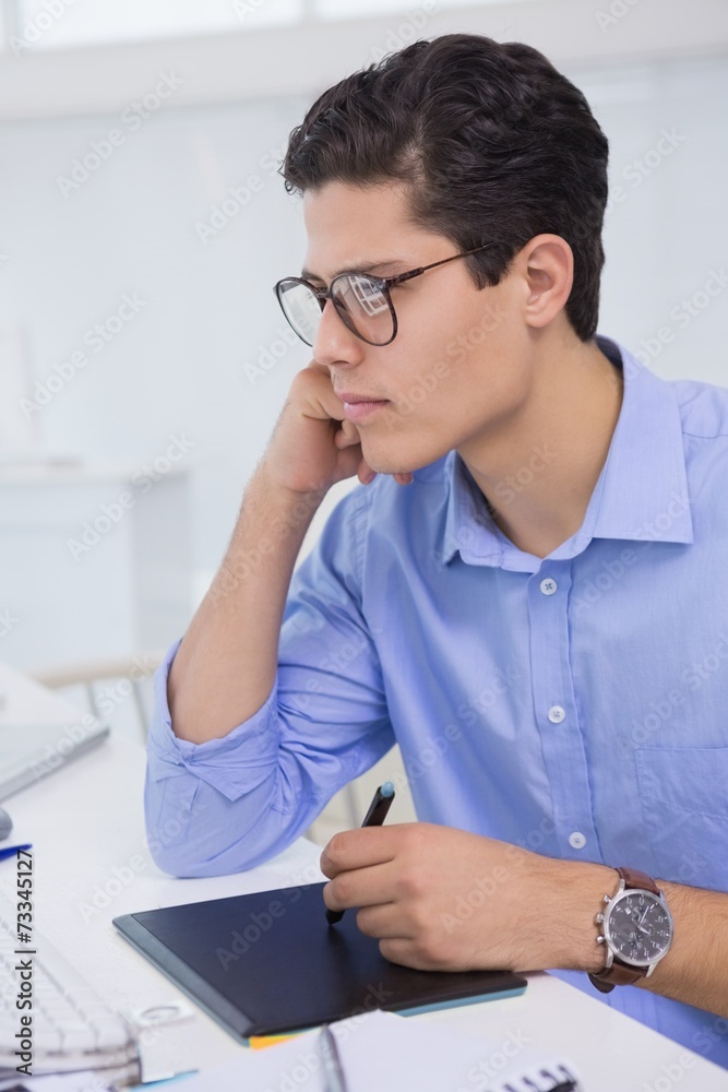 Casual graphic designer working at his desk Casual graphic designer working at his desk