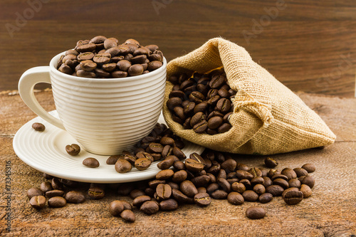 Brown roasted coffee beans in cup.