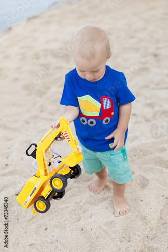 kleiner bub mit spielzeugbagger