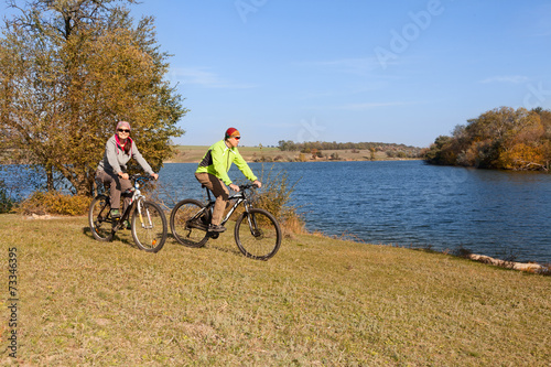 Happy mountain bike couple cycling outdoors a country walk near