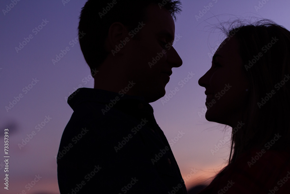 Closeup of couple looking at each other at sunset