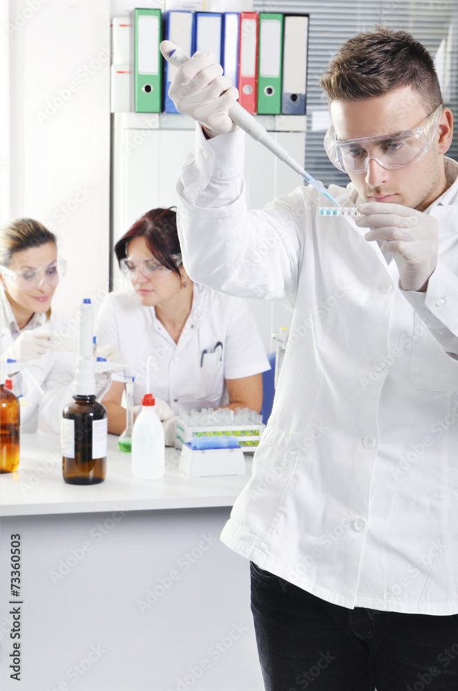 Attractive young PhD students scientists observing in the labora Attractive young PhD students scientists observing in the labora