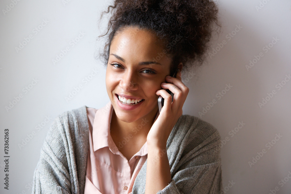 Young woman smiling and talking on mobile phone Young woman smiling and talking on mobile phone