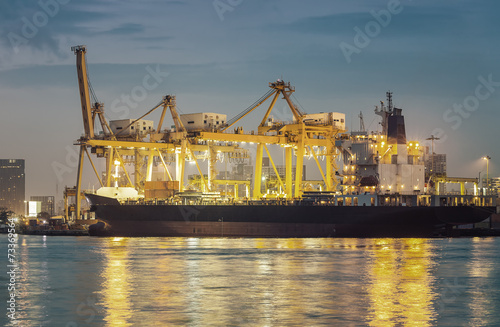 Gantry crane loading and unloading cargo container from cargo ship at port to show global international logistics and transportation by cargo ship and cargo container, Logistic import export concept.