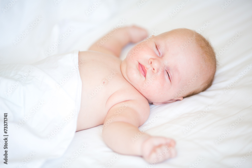 Peaceful newborn baby lying on a bed sleeping Peaceful newborn baby lying on a bed sleeping