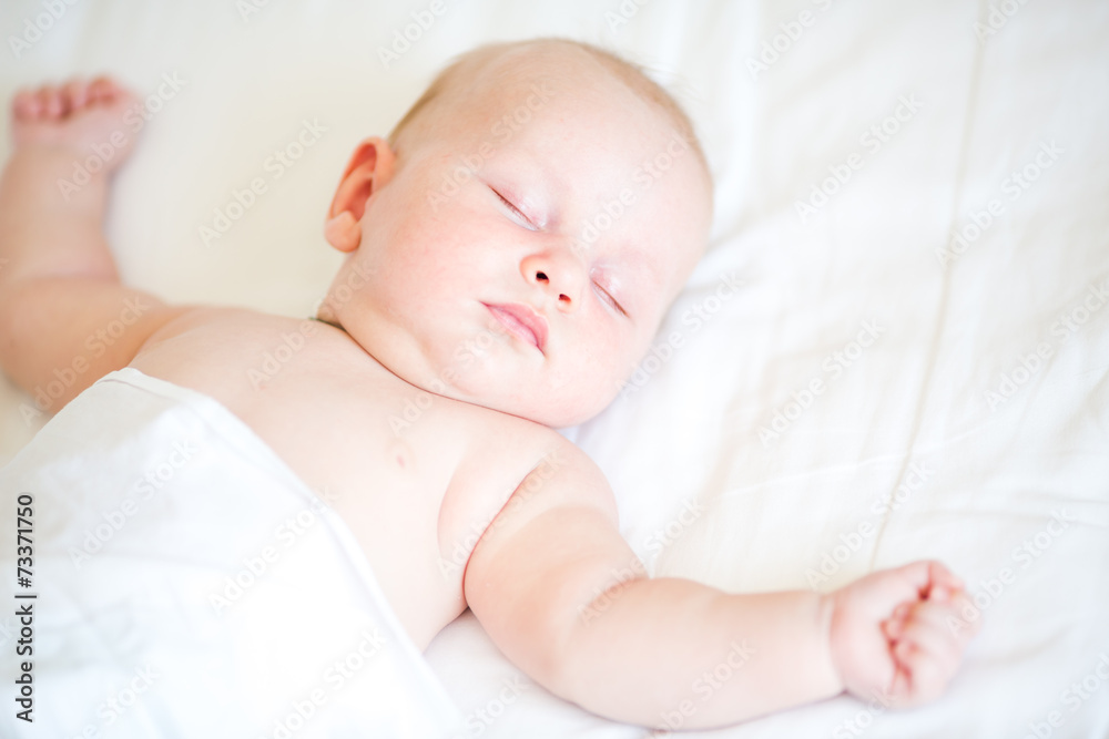 Peaceful newborn baby lying on a bed sleeping Peaceful newborn baby lying on a bed sleeping