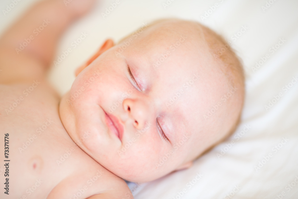 Peaceful newborn baby lying on a bed sleeping Peaceful newborn baby lying on a bed sleeping