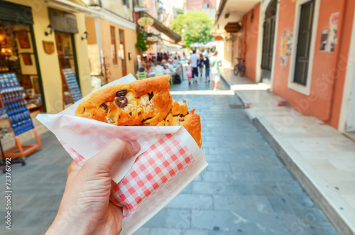 Fototapeta Naklejka Na Ścianę i Meble -  greek pie in hand - walking the streets