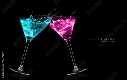 Fotografia Exotic Liquors. Stemmed cocktail glasses making a toast splashin