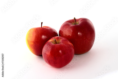 Three red apples on a white background