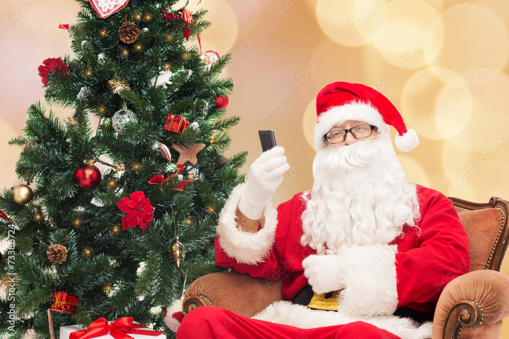 santa claus with smartphone and christmas tree santa claus with smartphone and christmas tree