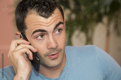 Young male dark haired male model talking on his cell phone