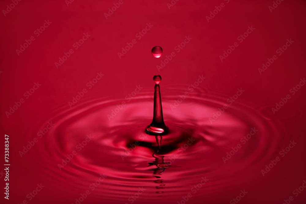 Water drop close up in red