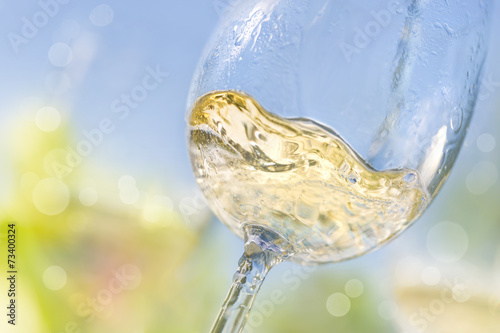 Close up of pouring white wine in a glass photo