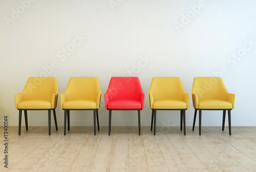Yellow chairs aligned with a red one in the middle