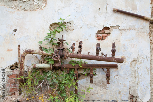 Old corroded water pipes with broken faucets