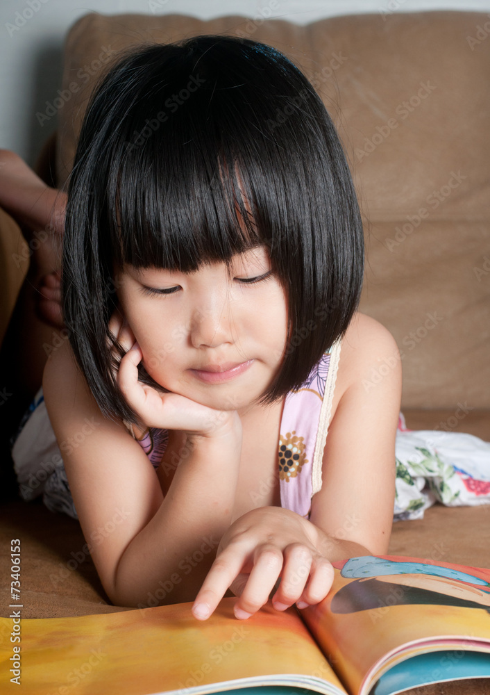 Asian little girl reading her book Asian little girl reading her book