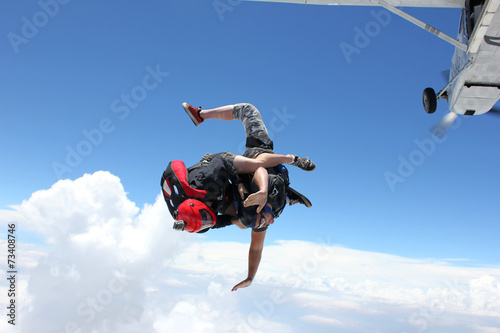 Two skydivers jump from an airplane