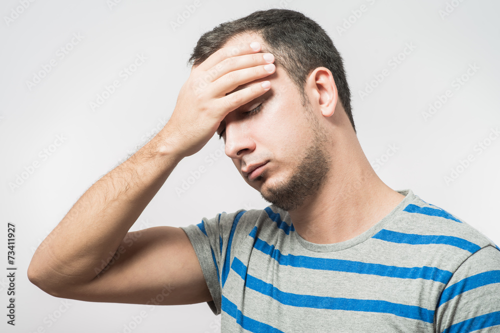 Depressed young man holding head in hands Depressed young man holding head in hands