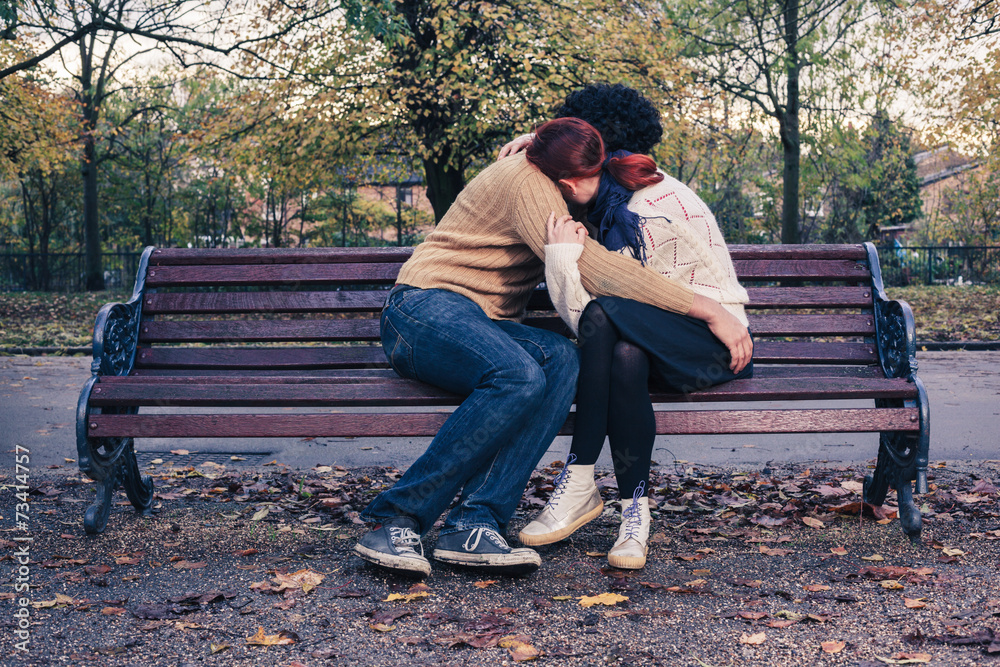 Sad young couple on park bench Sad young couple on park bench