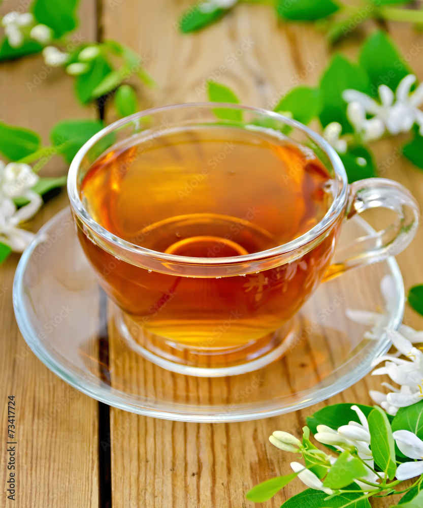 Tea with white flowers of honeysuckle on board
