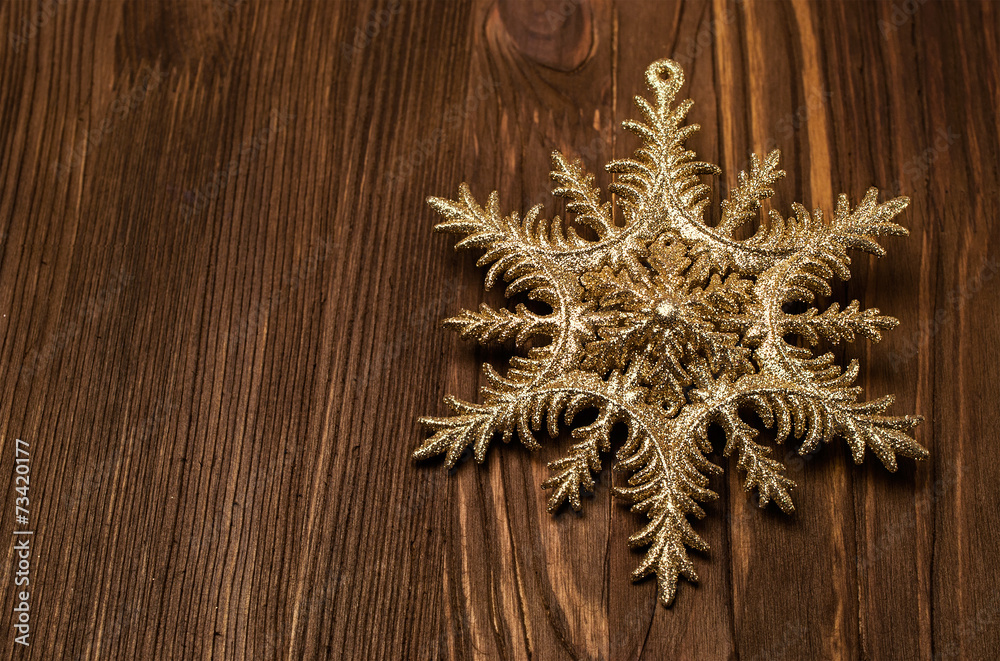Golden snowflake on a wood Golden snowflake on a wood